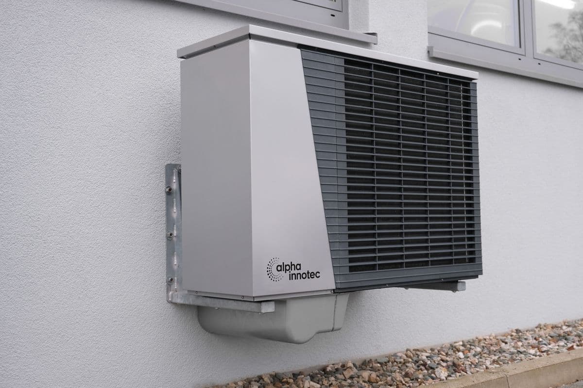 Wall-mounted heat pump outdoor unit on a home exterior
