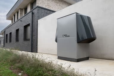 Heat pump outdoor unit installed beside a house