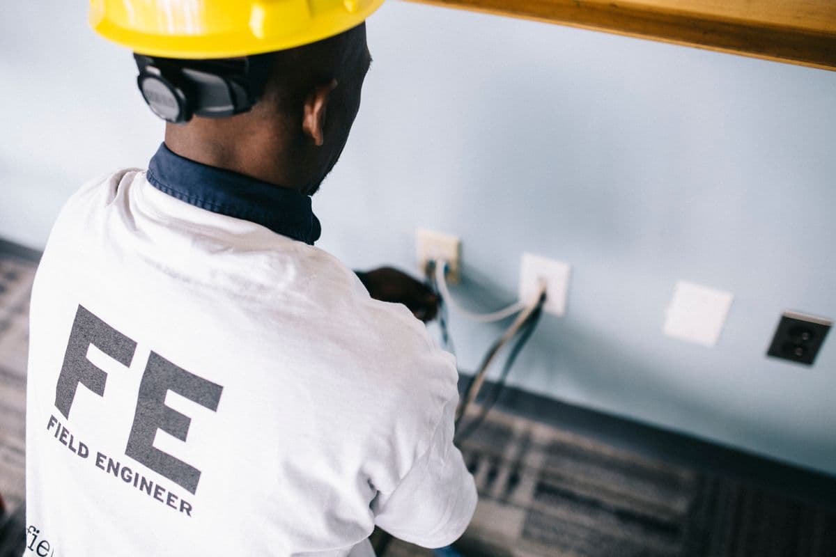 Field engineer working on air conditioner electrical connections