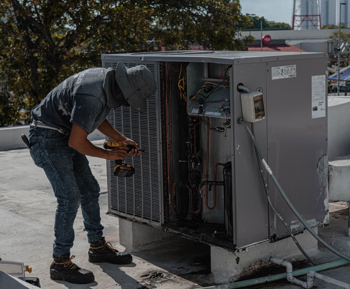HVAC technician repairing an outdoor air conditioning unit