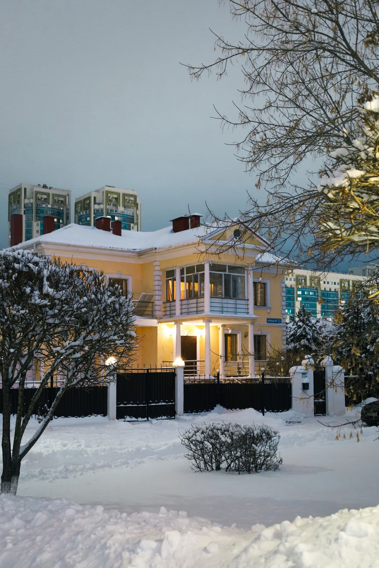 Warmly lit house in a snowy landscape at twilight
